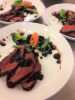 Reindeer meat placed on a plate with herbs and vegetables