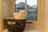 Black basked with white and blue towels on the window sill