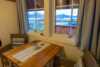 Dinning table with arm chairs in front of the windows