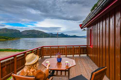 Dame på balkongen med fjordutsikt