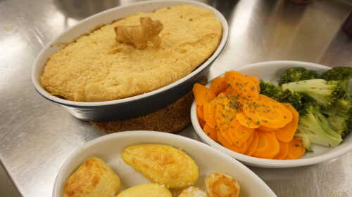 Moos pie in baking form with vegetables in serving bowl