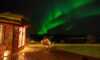 Man outside Aurora guest house under the Northern Lights