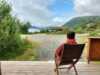 One person sitting on the terrace enjoying the fjord and mountain view
