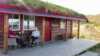 Two persons enjoying their coffee on the terrace outside the studio cabin